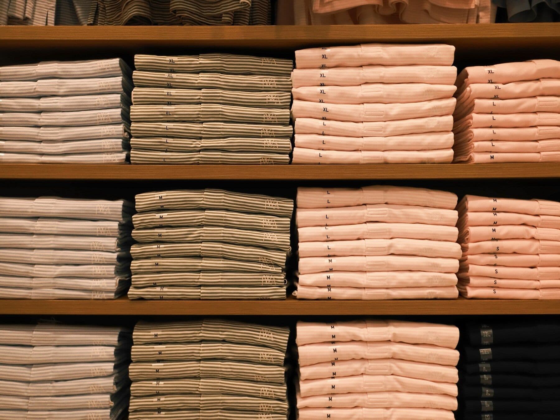 Folded shirts stacked on wooden shelves