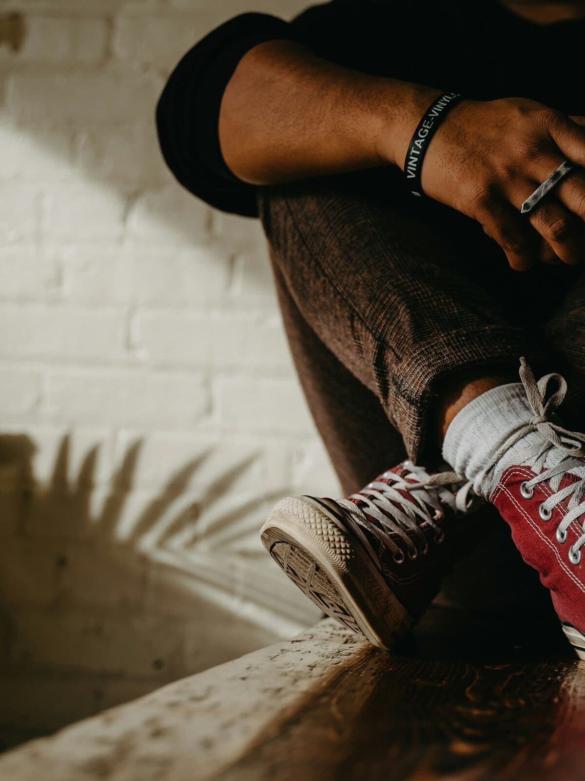 Close-up of grey trousers and sneakers