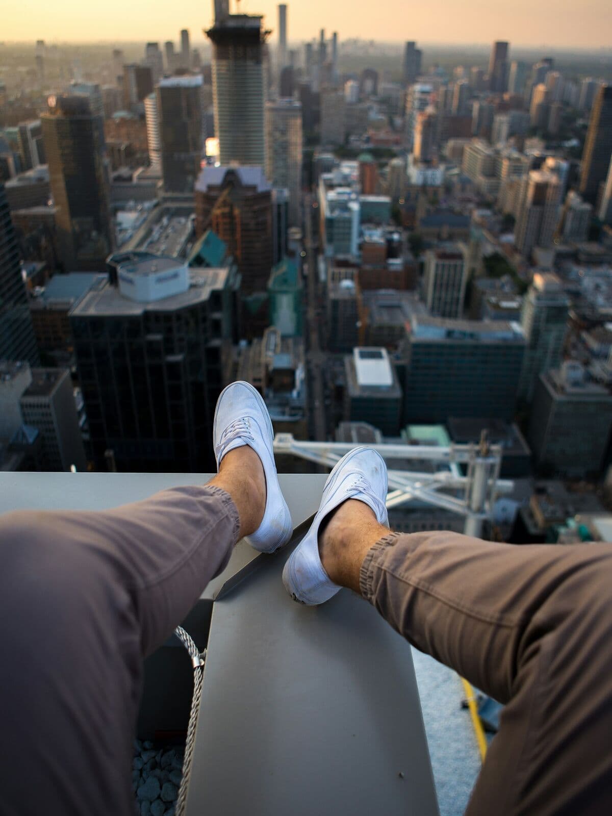 Brown joggers and white sneakers above a city skyline