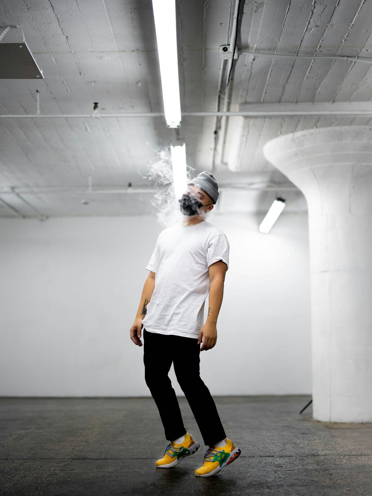 Model in a white t-shirt and black trousers in a concrete studio