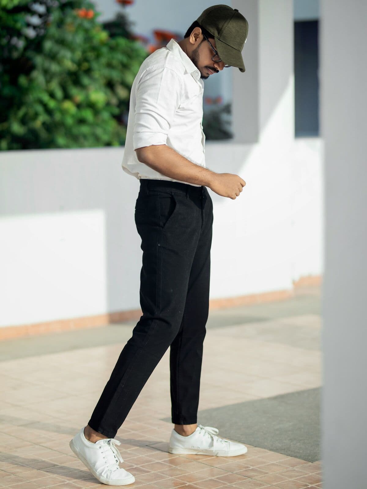 Model in a white t-shirt and black trousers walking