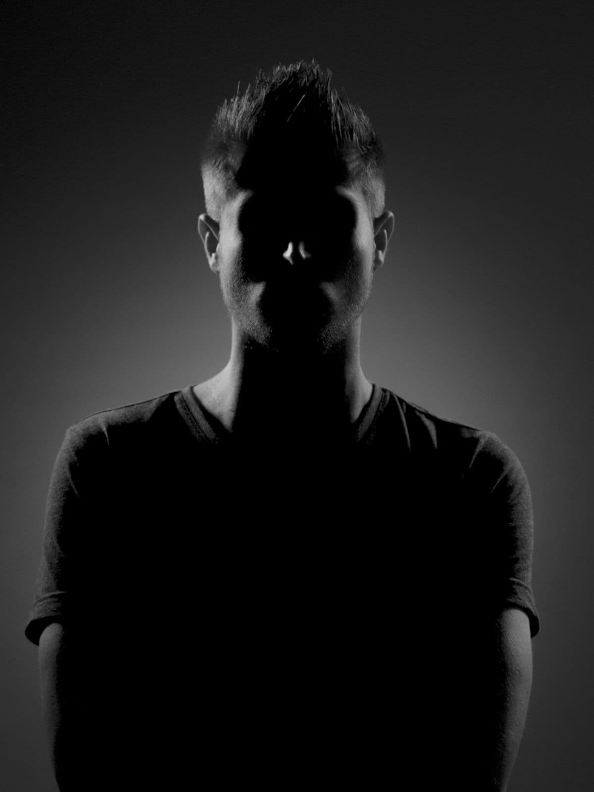 Backlit silhouette of a model in a black t-shirt