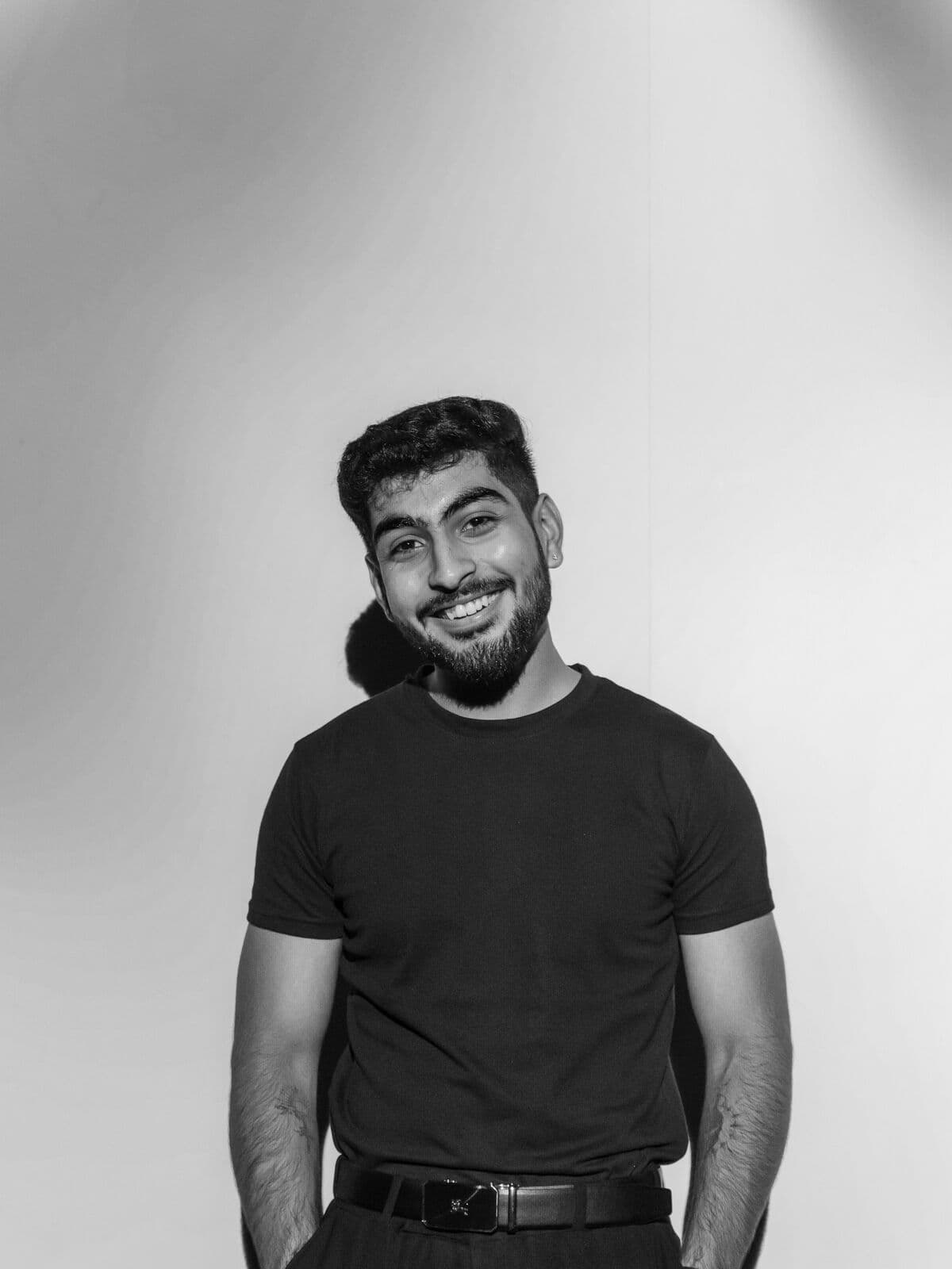 Model in a fitted black t-shirt against a grey backdrop